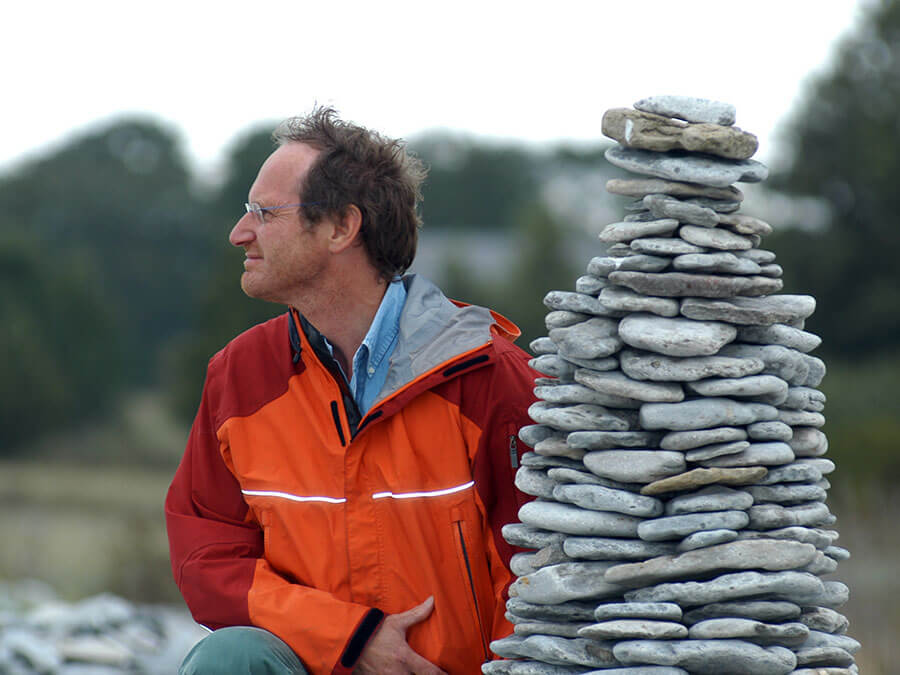 Michael Wachtler sits next to a cairn